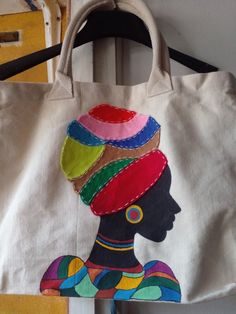 a canvas bag with an african woman's head painted on it