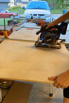 a person using a table saw to cut plywood