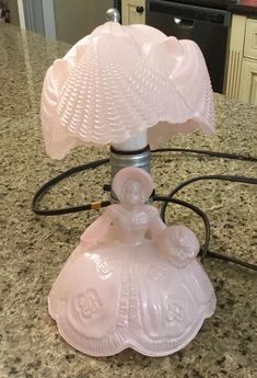 a pink lamp sitting on top of a counter next to an oven and stovetop