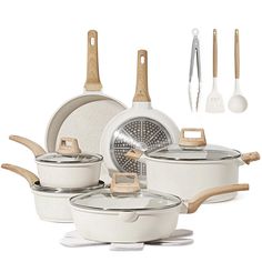 an assortment of white pots and pans with wooden spoons, spatulas and utensils