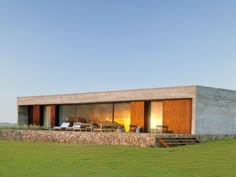 the house is made out of concrete and has sliding glass doors