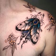 a woman's chest with an intricate butterfly tattoo on it, and flowers around the breast