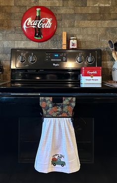 a black stove top oven sitting under a coca cola sign