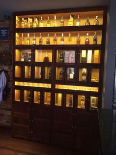 a room filled with lots of bottles of alcohol on shelves next to a brick wall