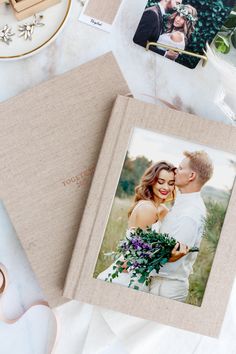 an open photo book with two photos on it next to some scissors and other items