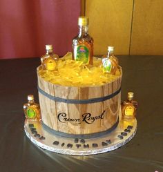 a birthday cake made to look like a barrel with liquor bottles in it on a table