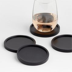 three black coasters and one empty wine glass