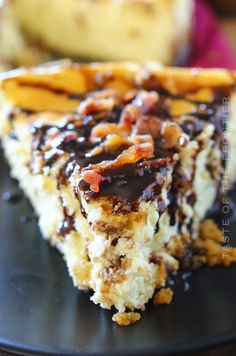 a close up of a piece of cake on a plate with chocolate sauce and nuts