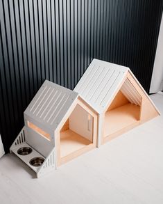 the dog house is built into the floor and has two bowls in front of it