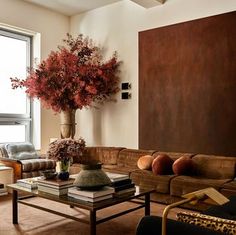 a living room filled with furniture and a tall vase on top of a coffee table