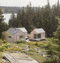 two small houses sitting on top of a lush green hillside