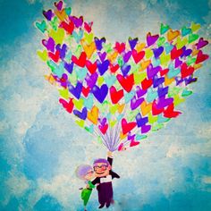 a person holding a bunch of hearts in the air with a kite attached to it