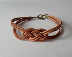 a brown leather bracelet with a knot on it