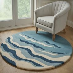 a white chair sitting on top of a wooden floor next to a blue and white rug