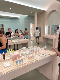 people are looking at products on display in a beauty store while others stand around the counter