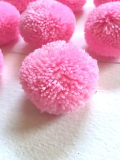 several pink pom - poms on a white surface