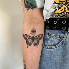 a woman's arm with a butterfly tattoo on the left side of her arm