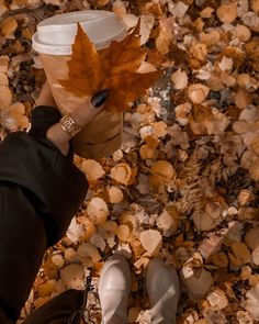 a person holding a coffee cup with a leaf on it