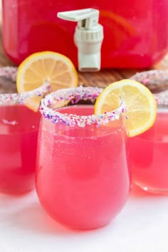 three glasses filled with pink lemonade and sprinkles next to a crock pot