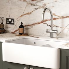 a white sink sitting under a faucet in a kitchen