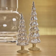 two crystal christmas trees sitting on top of a wooden table