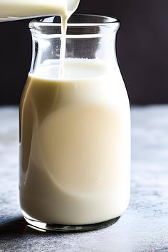 milk being poured into a glass pitcher