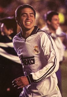 the soccer player smiles as he runs with his team mates