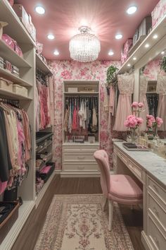 a walk in closet filled with lots of pink and white furniture next to a chandelier