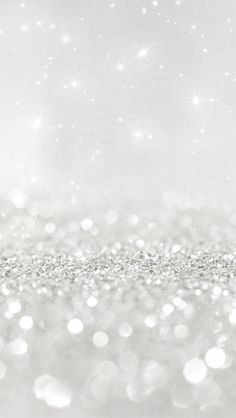 a blurry image of gold and white glitter with stars in the sky behind it