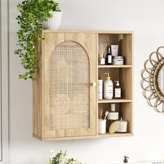 a wooden cabinet with some bottles and soaps on it next to a potted plant