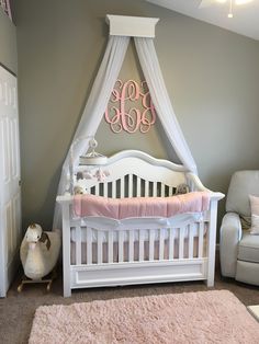 a baby's room with a white crib and pink bedding