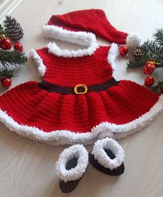 a crocheted santa clause dress and booties on the floor