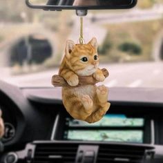 a cat ornament hanging from the dashboard of a car