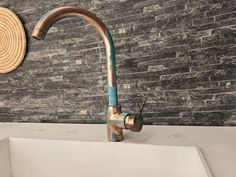 an old faucet is on display in front of a brick wall with a straw hat