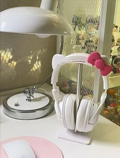 a desk with headphones and a lamp on it