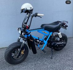 a blue motorcycle parked next to a gray wall