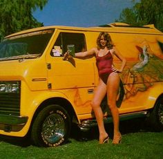 a woman in a bathing suit standing next to a yellow van with an advertisement on it