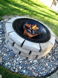 an outdoor fire pit with rocks and gravel around it