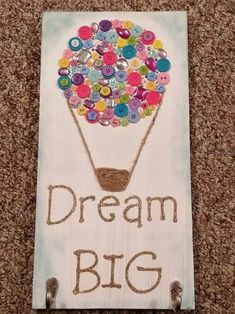 a sign that says, dream big with a hot air balloon in the shape of a basket