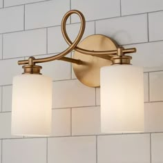 a bathroom light with three lights on it and white tile wall behind the light fixture