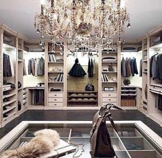 an open closet with a chandelier hanging from the ceiling