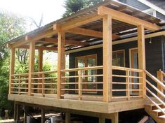 a house that is built into the side of a wooden deck with stairs leading up to it