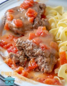 a close up of a plate of food with pasta and meat in gravy