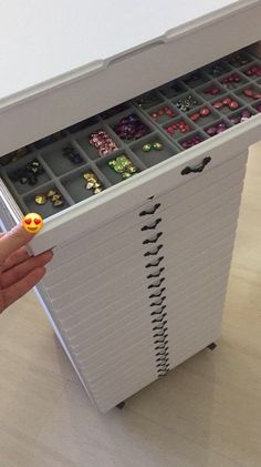 a person holding a box with many different items in it on top of a table