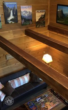 a living room with wood paneling and pictures on the wall above it's couch