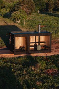 a small wooden structure in the middle of a field