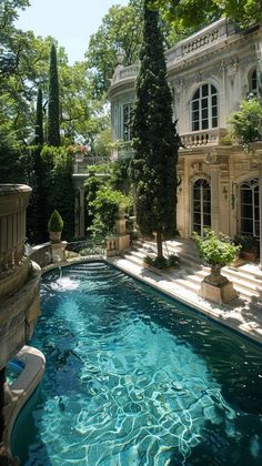 an outdoor swimming pool surrounded by trees and bushes