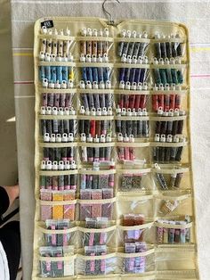 a person sitting in front of a large case filled with lots of crafting supplies