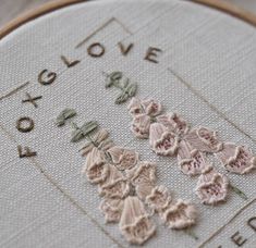 a close up of a cross stitch with flowers on it