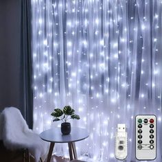 there is a remote control on the table in front of the curtain with lights behind it